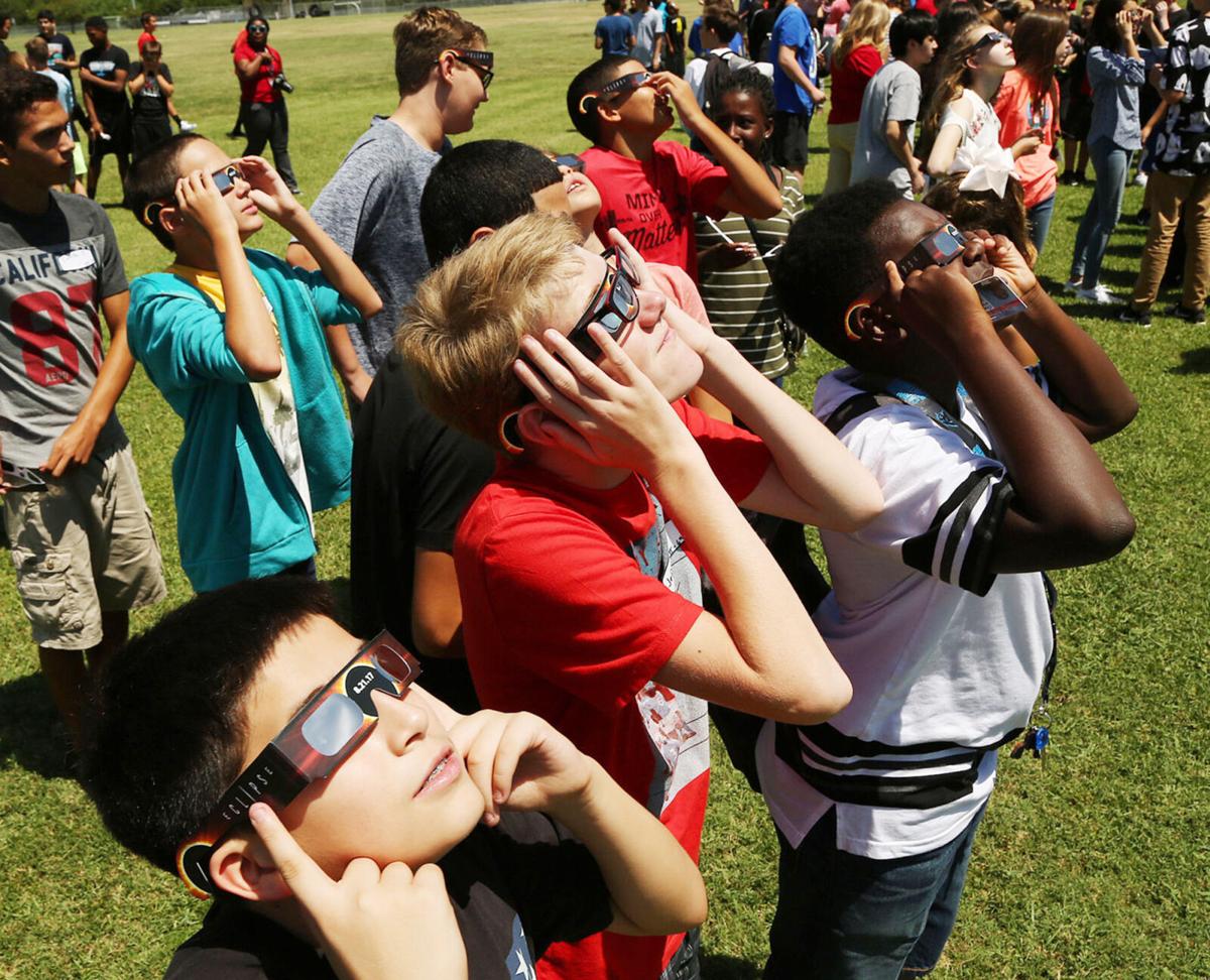 Children watching eclipse with eclipse glasses on