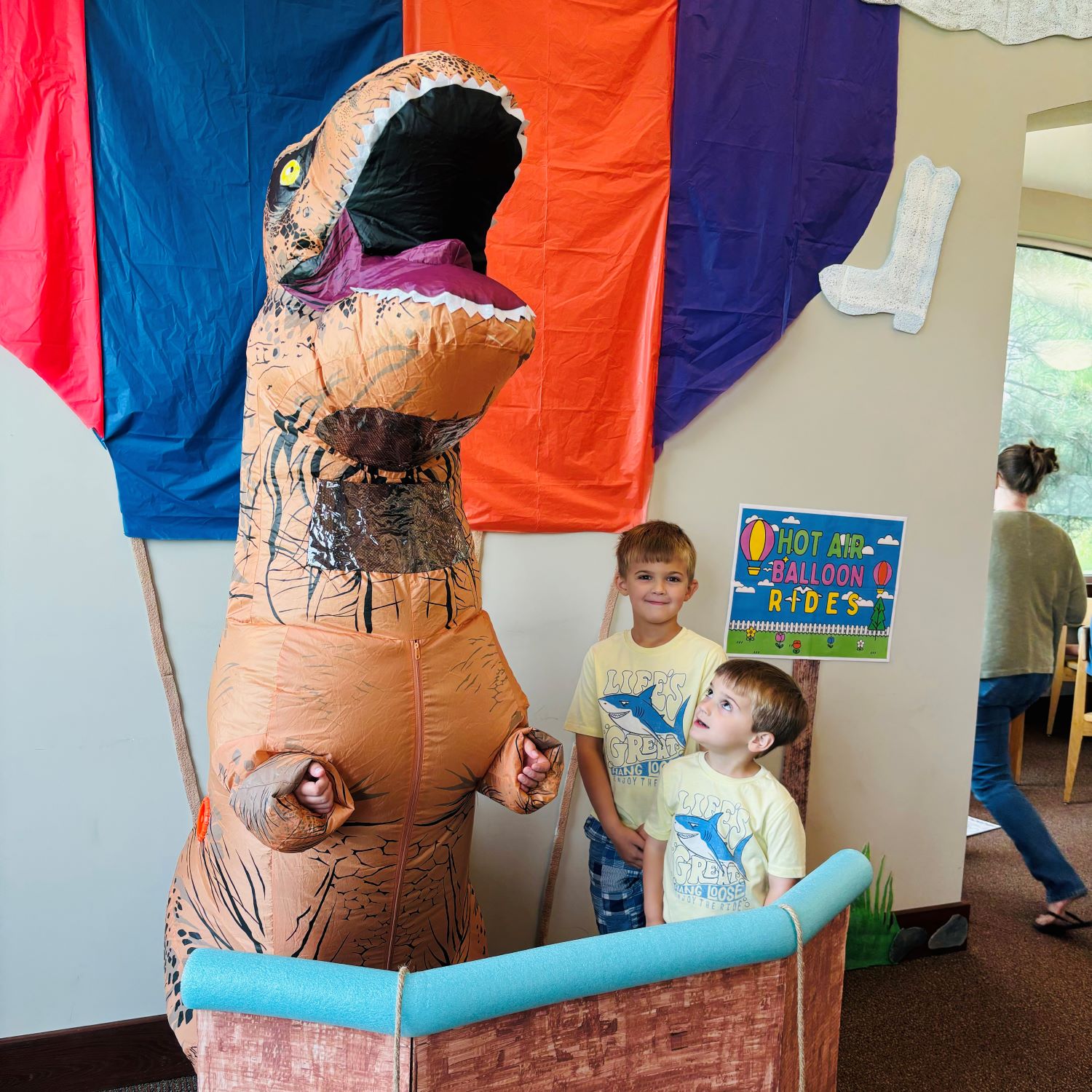 T-Rex and two boys in hot air balloon