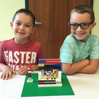 Two boys show off their lego creation