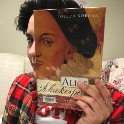 example of someone making a bookface by holding up a book to their face