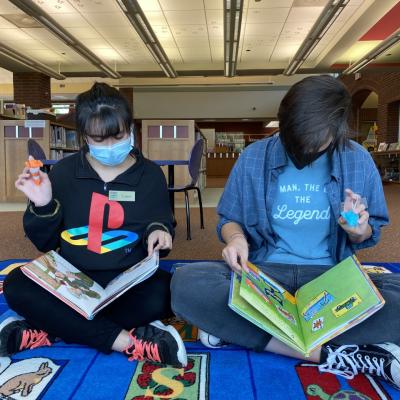 two people reading to their reading buddies