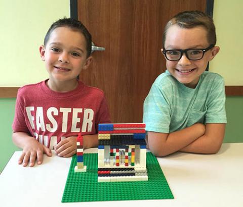 Two boys show off their lego creation