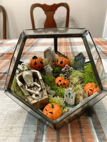 Glass terrarium filled with tiny Halloween decorations