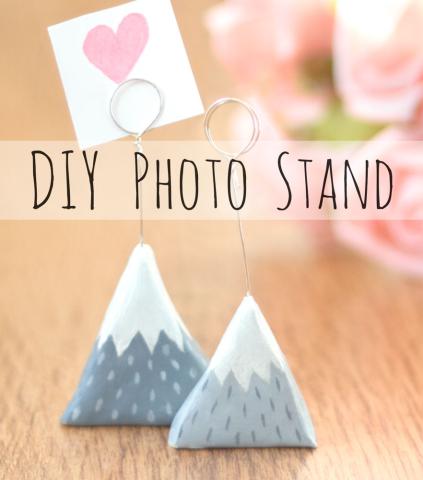 Two clay mountain photo stands sitting against a wood type background with some other images in the further background. 