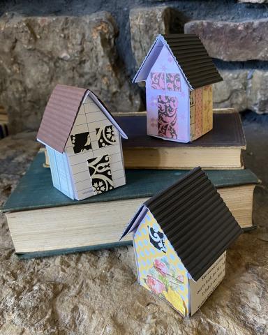 three crafty cottages sitting on a pile of books